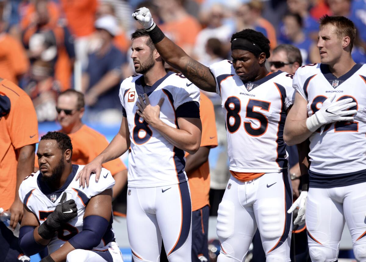 Denver Broncos tight end Virgil Green (85) gestures as teammate Max Garcia, left, takes a knee during the playing of the national anthem prior to an NFL game against the Buffalo Bills on Sept. 24. (Adrian Kraus / Associated Press)