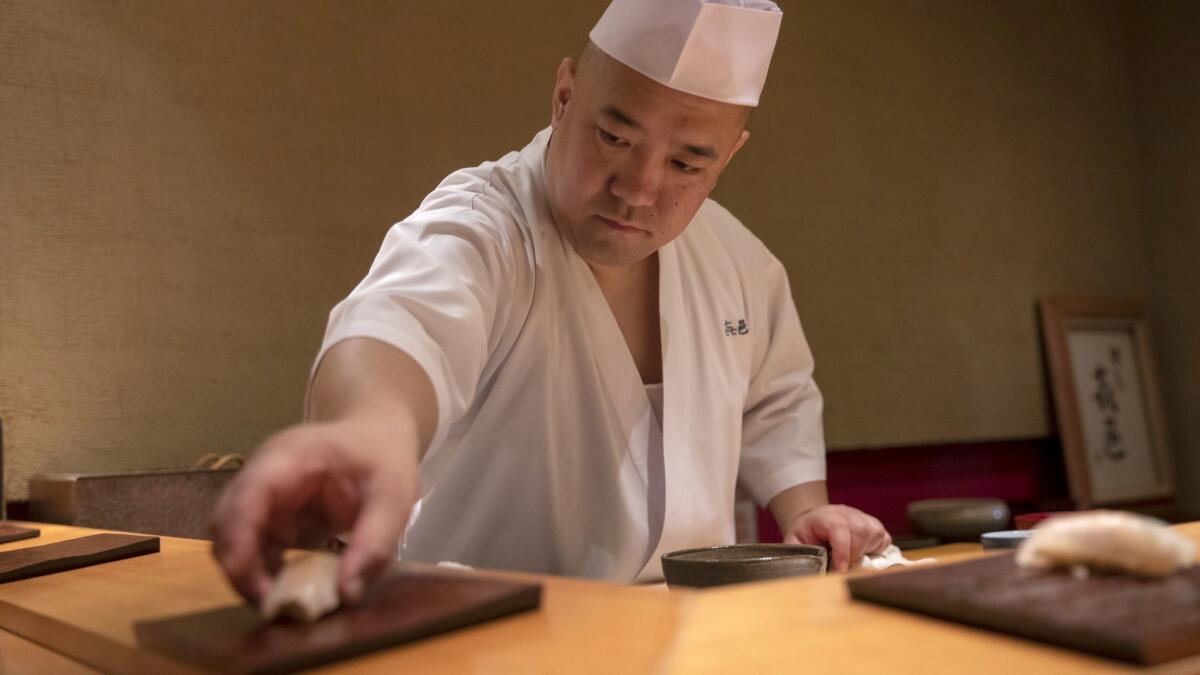 Chef Koji Kimura serves sushi during dinner service at his restaurant Kimura in Tokyo.