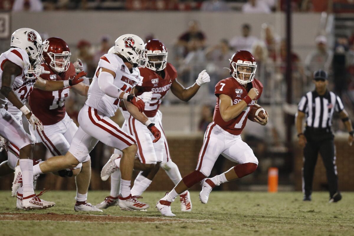 FILE - In this Sept. 7, 2019 file photo, Oklahoma quarterback Spencer Rattler (7) carries in the fourth quarter of an NCAA college football game against South Dakota, in Norman, Okla. The coronavirus pandemic has shut down much of Division I football, but with three of the Power Five leagues still playing, there are still some big games to look forward to. Oklahoma takes on Texas on Oct. 10, 2020. (AP Photo/Sue Ogrocki, File)