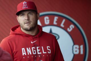 Anaheim, CA - July 18: Angels star Mike Trout walks in the dugout before a game.