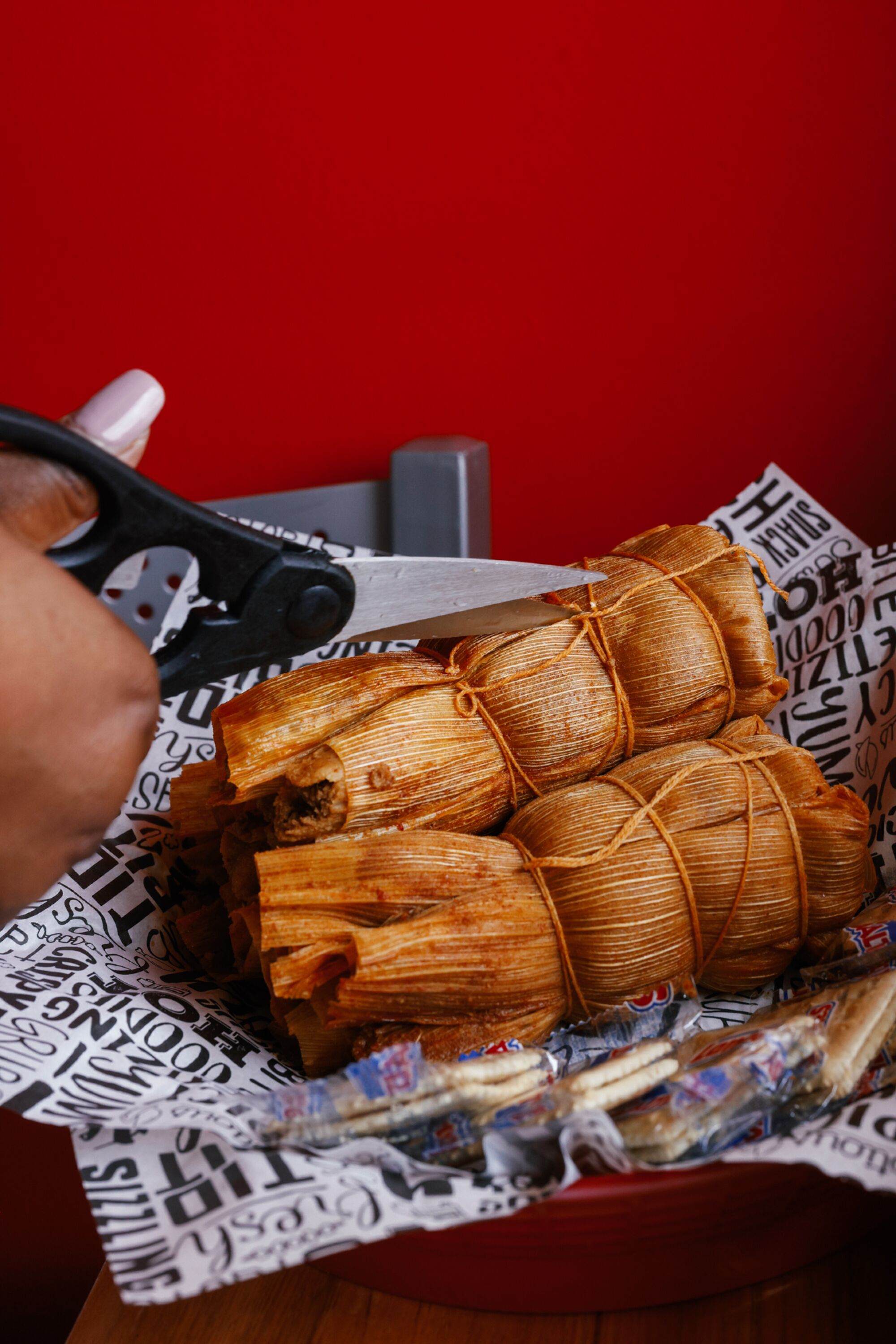 Scissors are used to cut the strings on husk-wrapped tamales.
