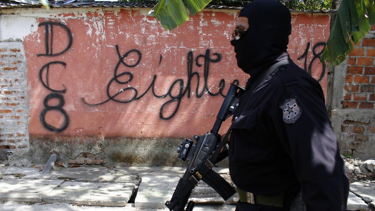 A masked and armed policeman patrols a gang-controlled neighborhood in San Salvador, El Salvador on April 5, 2016.