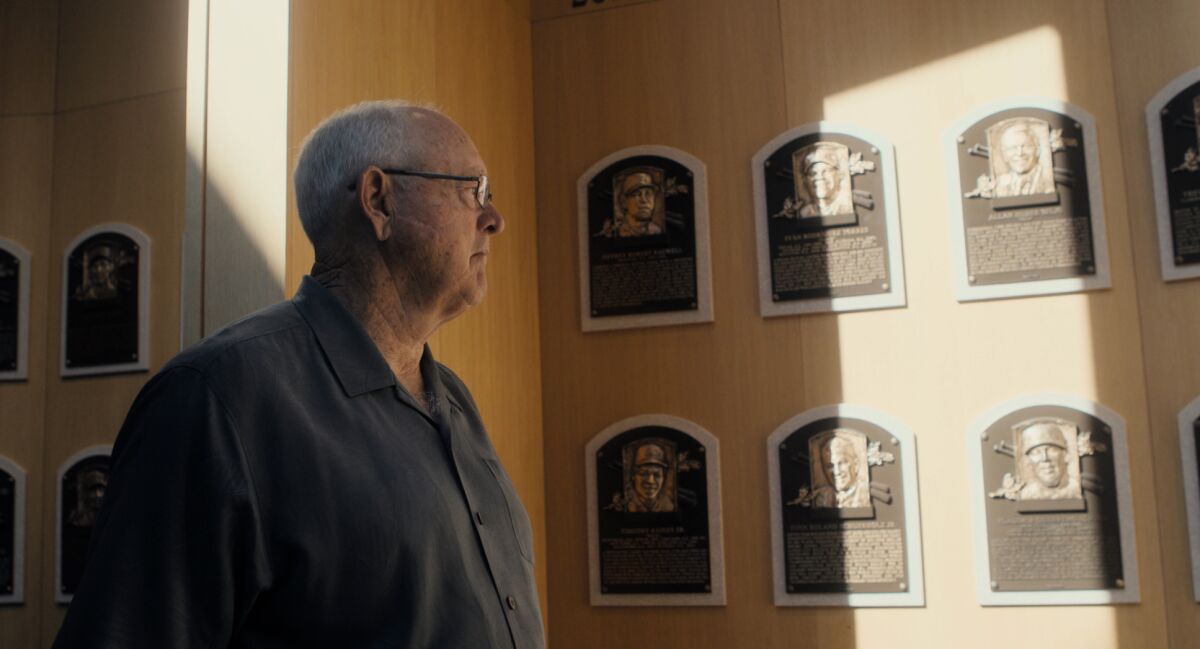 A man looks at plaques on a wall at the Baseball Hall of Fame in the documentary "Facing Nolan."