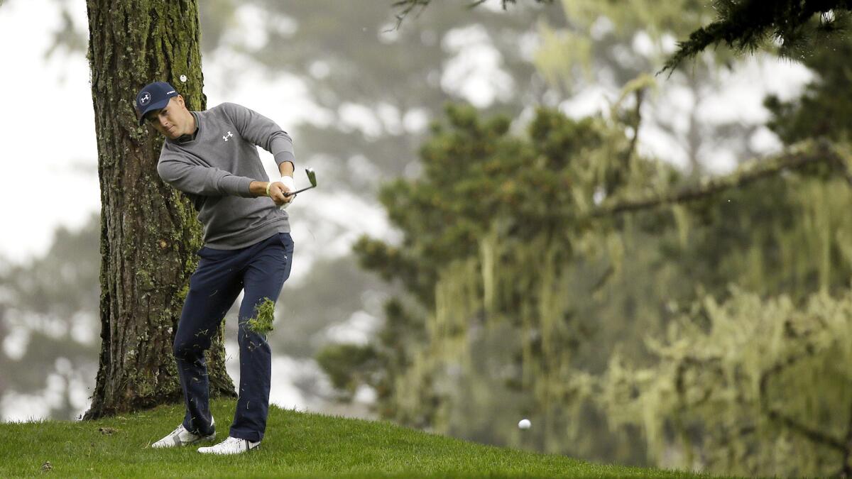Jordan Spieth hits a shot from under trees along the 10th fairway at Spyglass Hill Golf Course during the second round of the AT&T Pebble Beach Pro-Am on Friday.