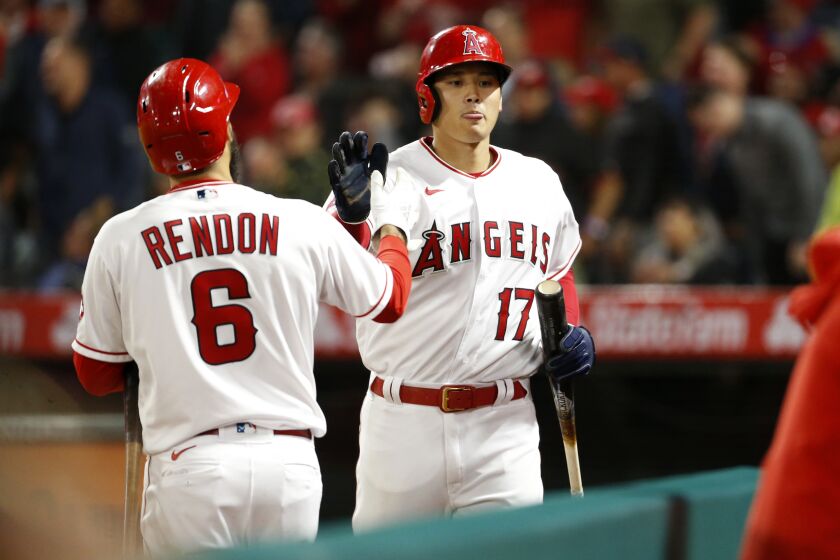 ANAHEIM, CA - APRIL 27: Los Angeles Angels designated hitter Shohei Ohtani (17) is congratulated by Los Angeles Angels third baseman Anthony Rendon (6) after scoring on a double hit by Los Angeles Angels center fielder Mike Trout (27) in the bottom of the sixth inning against the Cleveland Guardians at Angel Stadium of Anaheim on Wednesday, April 27, 2022 in Anaheim, CA. (Gary Coronado / Los Angeles Times)
