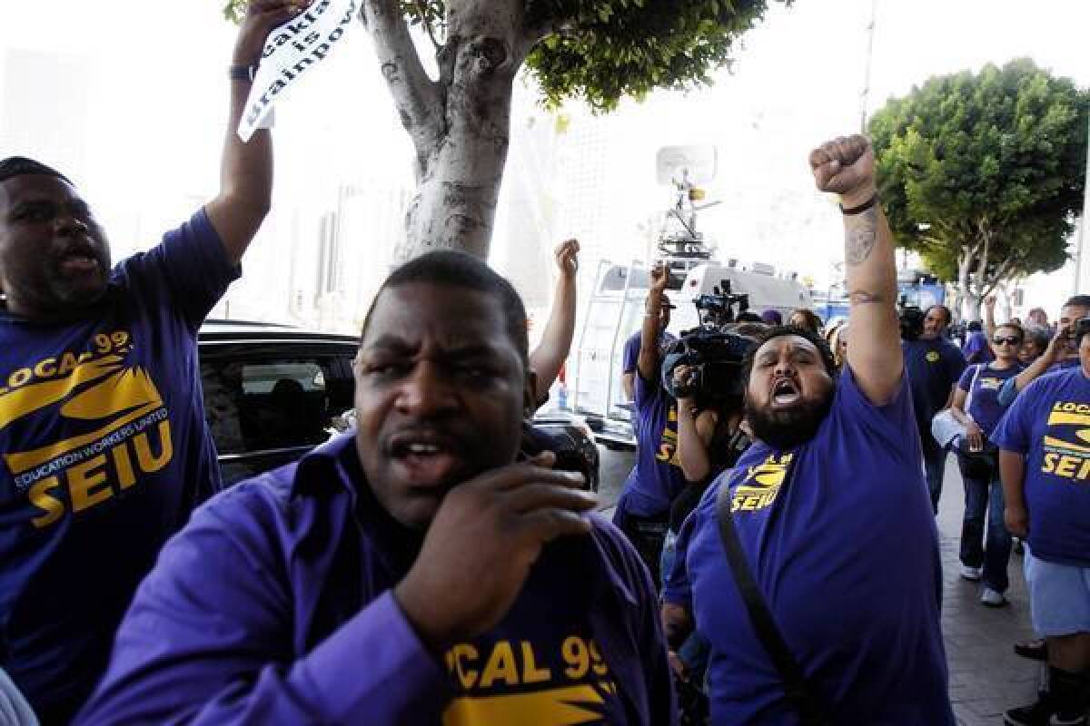 Gama Andrade, right, raises a fist in victory while celebrating with other members of SEIU Local 99 after the school board voted to continue funding a classroom breakfast program. Andrade has been working in the Farmdale Elementary School cafeteria for 12 years. "We can breathe a little easier," he said about the vote allowing him to keep his job.