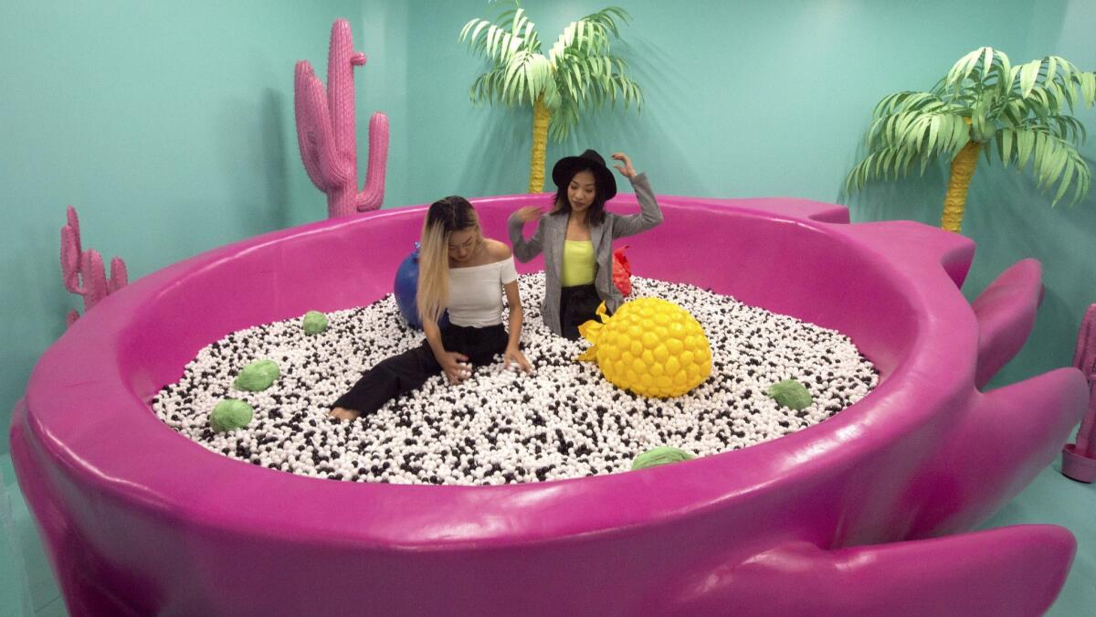 Stacy Ju, left, and Kwihn Pham in the Dragon Fruit Pool in the Tropical Desert Oasis room at the World of Fruit pop-up.