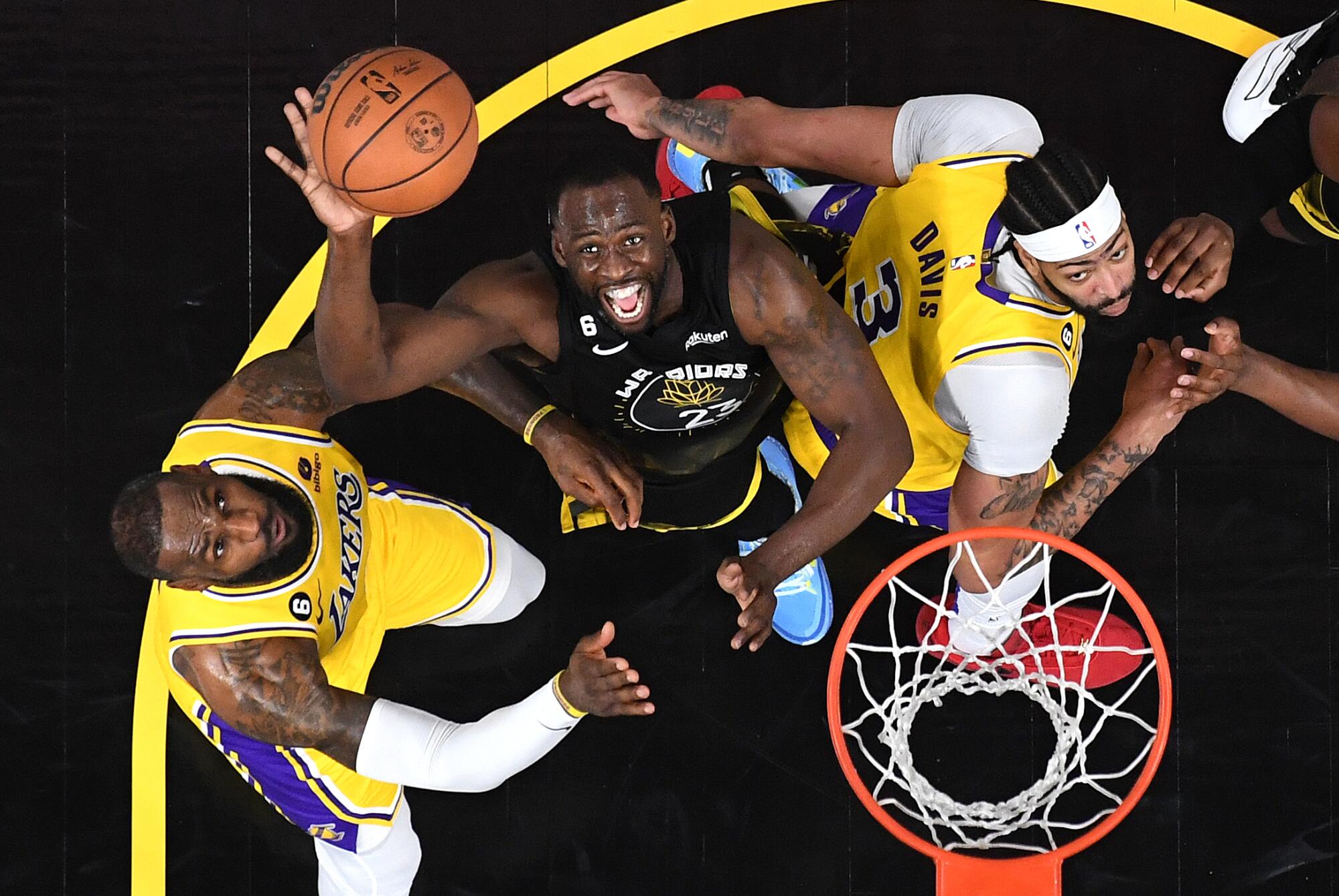 Lakers LeBron James, left, and Antony Davis battle for a rebound against Warriors Draymond Green in the first half.