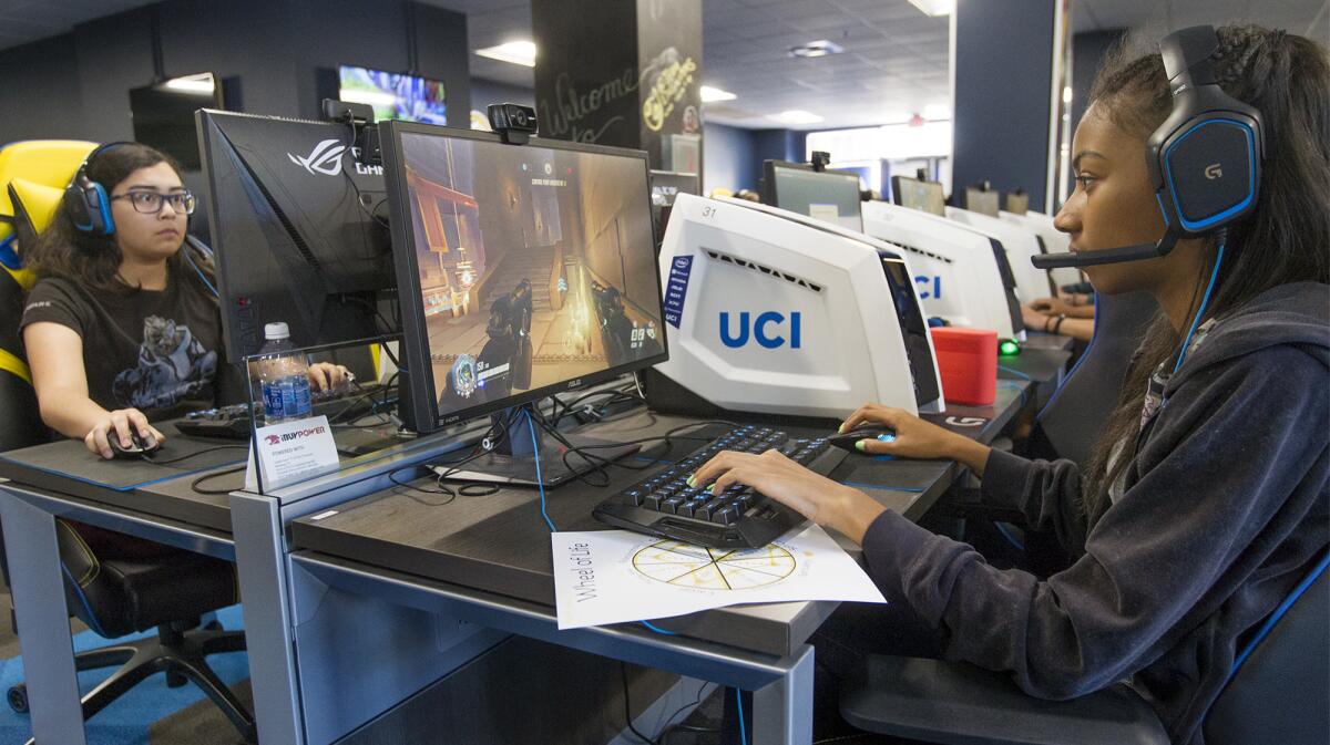 From right to left, Nyah Beck, 18, of Northridge and Katherine Correa, 19, of Murrieta play an online game called "Overwatch" at UCI's eSports arena during a gaming summer camp for girls.