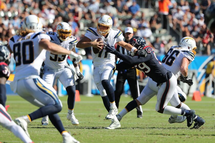 CARSON, CA - SEPTEMBER 22, 2019: Los Angeles Chargers quarterback Philip Rivers (17) tries to evade the sack of Houston Texans outside linebacker Whitney Mercilus (59) and ending up fumbling on the play in the second half at Dignity Health Sports Park on September 22, 2019 in Carson, California. (Gina Ferazzi/Los AngelesTimes)