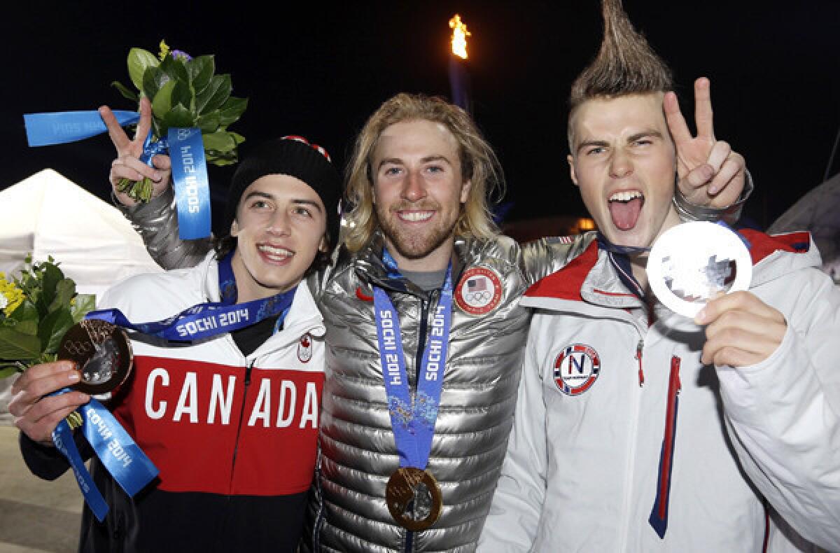 Gold medalist Sage Kotsenburg of the U.S. is flanked by silver medalist Staale Sandbech of Norway, right, and bronze medalist Mark McMorris of Canada during a photo session at the awards ceremony for snowboard slopestyle on Saturday.