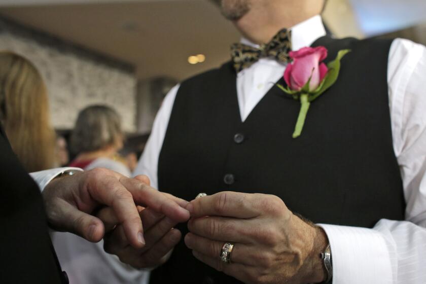 Steve Visano, 54, places a ring on his partner's hand during a group wedding ceremony in Fort Lauderdale, Fla. Republican presidential hopefuls have been asked whether they would attend a gay wedding. Some said they would, some not; still others avoided a direct reply.