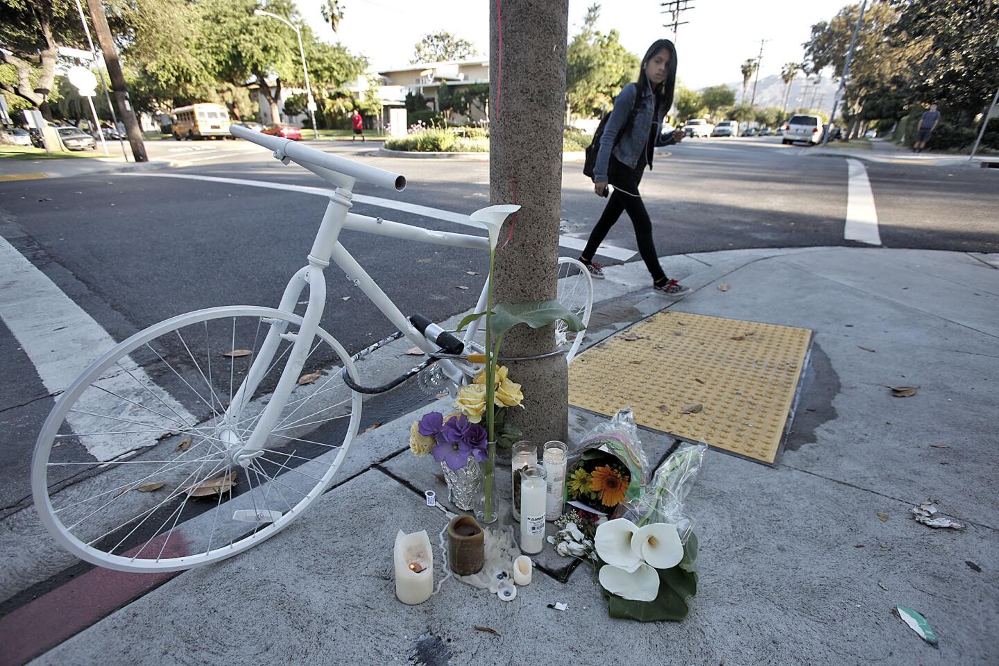 A Roosevelt Middle School student passes by memorial in memory of fellow student Jonathan Hernandez at Columbus Ave. and Riverdale Dr. in Glendale on Friday, May 3, 2013. Hernandez was hit by a school bus while he was going home on his bicycle the day before.