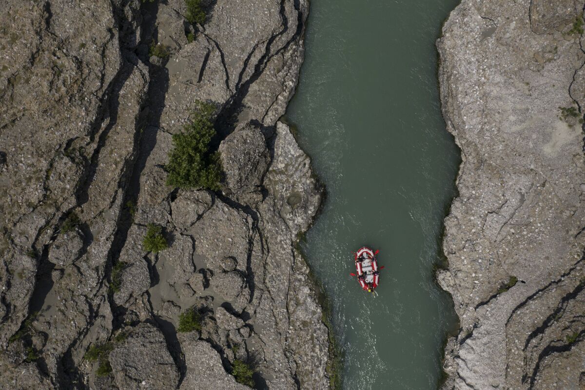 FILE - People raft on the Vjosa River near Permet, Albania, June 25, 2019. Albanian officials on Monday, June 13, 2022, declared the Vjosa River and its tributaries a future national park, a move aimed at preserving what they called one of the last wild rivers in Europe. The Albanian Ministry of Tourism and Environment signed an agreement with the California-based Patagonia environmental organization to draft an “integrated and sustainable plan" for the new park. (AP Photo/Felipe Dana, File)