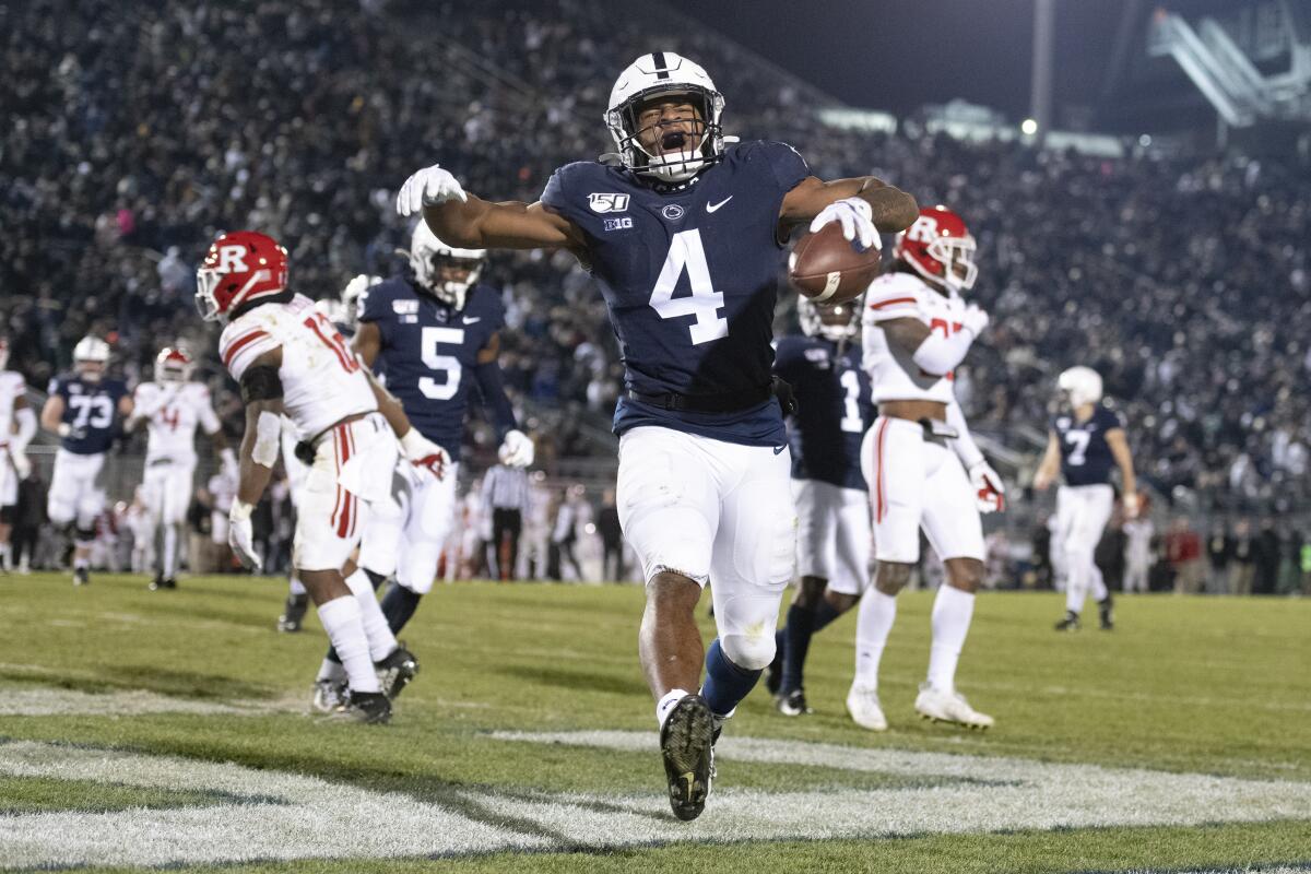 FILE - Penn State running back Journey Brown (4) celebrates his third quarter touchdown run against Rutgers during an NCAA college football game in State College, Pa, Nov. 30, 2019. Brown thought he was headed for an NFL career after starring as a running back at Penn State, but now after a heart condition diagnosis, he is working towards a career as a NASCAR pit crew. (AP Photo/Barry Reeger, File)
