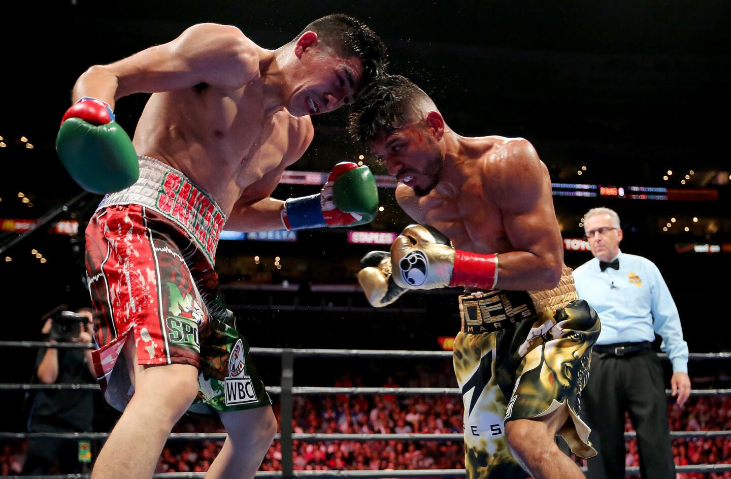 Leo Santa Cruz, left, and Abner Mares exchange punches during their featherweight fight on Saturday night at Staples Center.