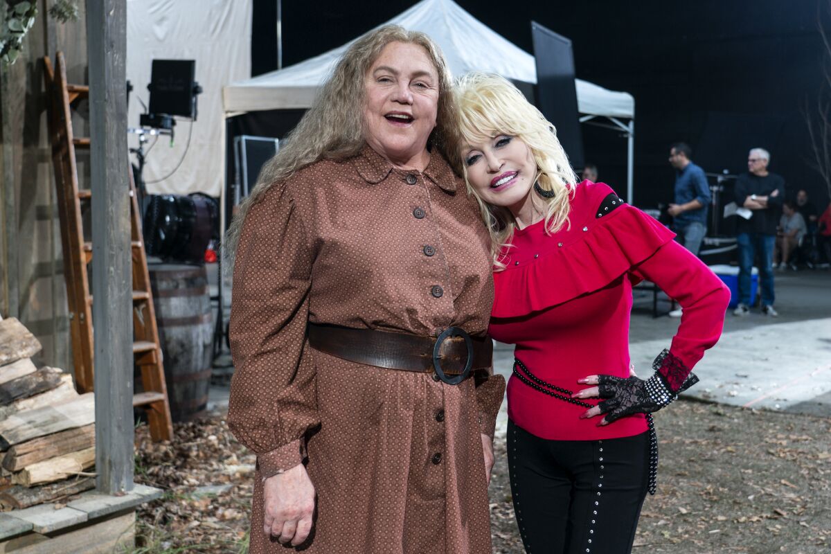 Kathleen Turner, left, and Dolly Parton on the set of "Dolly Parton's Heartstrings," a Netflix anthology series.