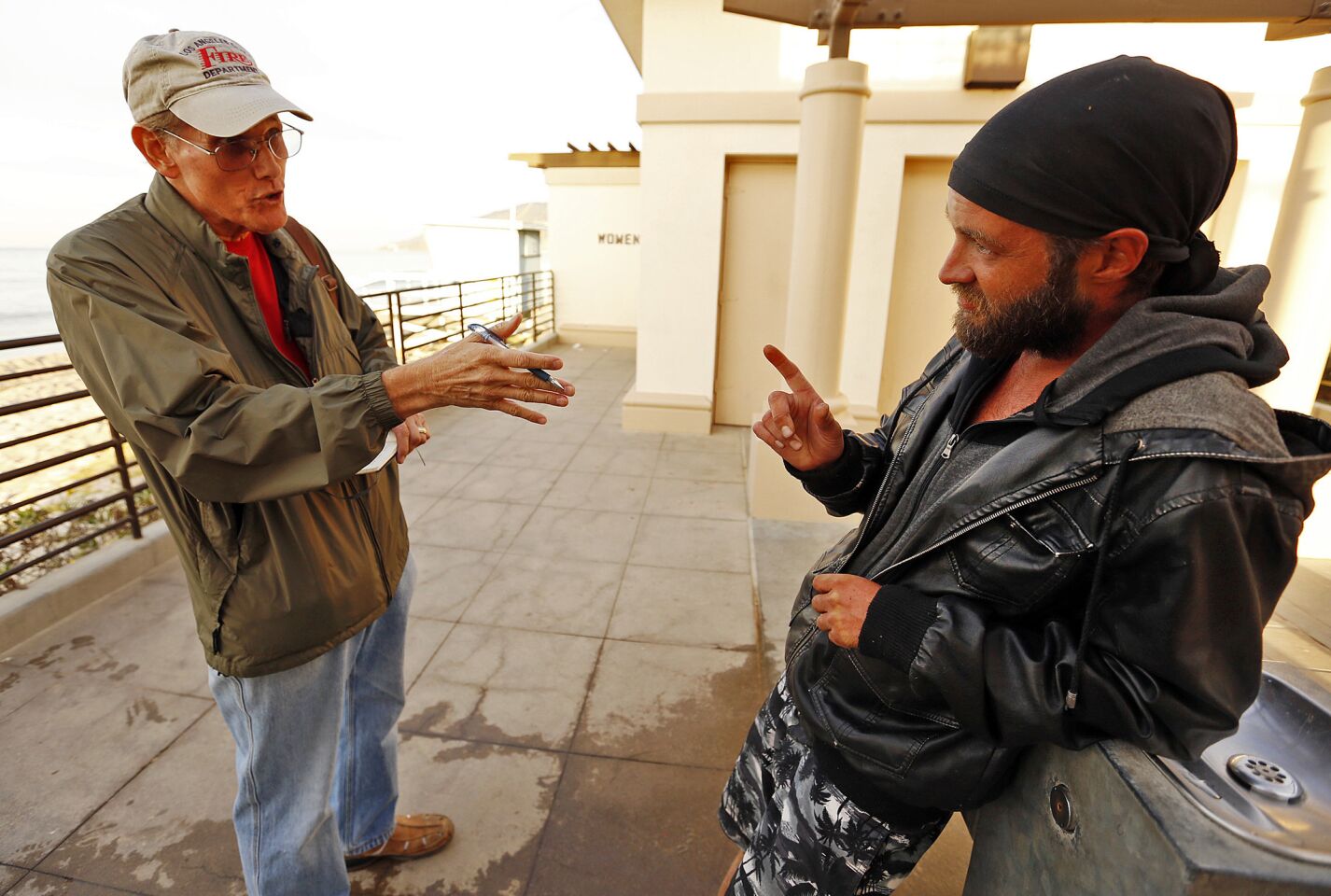 Patrick Hart, left, with the Pacific Palisades Task Force on Homelessness, talks to Brad Mark Kowalski, who is living near the beach, one of several homeless who are living in hidden encampments along Will Rogers State Beach.