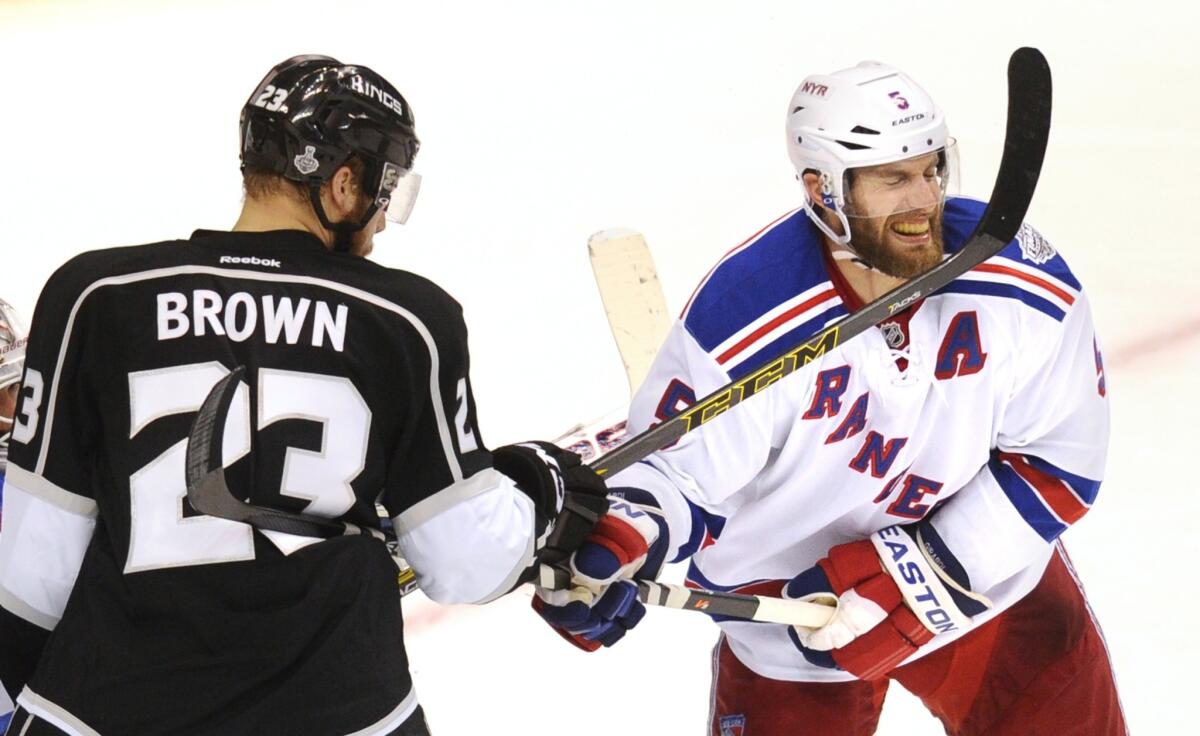 Kings right wing Dustin Brown clips Rangers defenseman Dan Girardi in the chin with his stick as they cross paths in the second period.