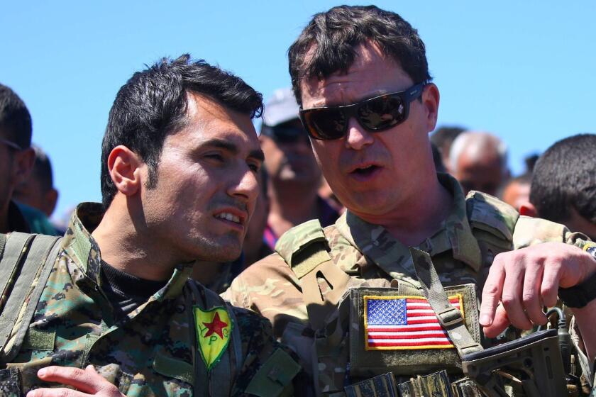 (FILES) This file photo taken on April 25, 2017 shows a US officer, from the US-led coalition, speaking with a fighter from the Kurdish People's Protection Units (YPG) at the site of Turkish airstrikes near northeastern Syrian Kurdish town of Derik, known as al-Malikiyah in Arabic. Syria's Kurds fear the steadfast ally they found in the US to successfully take on Islamic State group jihadists may now leave them to face threats from Turkey and Damascus alone. / AFP PHOTO / DELIL SOULEIMANDELIL SOULEIMAN/AFP/Getty Images ** OUTS - ELSENT, FPG, CM - OUTS * NM, PH, VA if sourced by CT, LA or MoD **