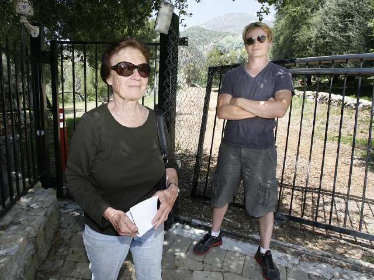Greta Pruitt and Paul Story stand in front of a gate at the top of Briggs Avenue where it turns onto Shields Street in La Crescenta.