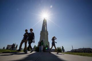 Los Angeles, CA - June 21: The sun is out as visitors walk past the Astronomers Monument at the Griffith Observatory on Wednesday, June 21, 2023 in Los Angeles, CA. (Brian van der Brug / Los Angeles Times)