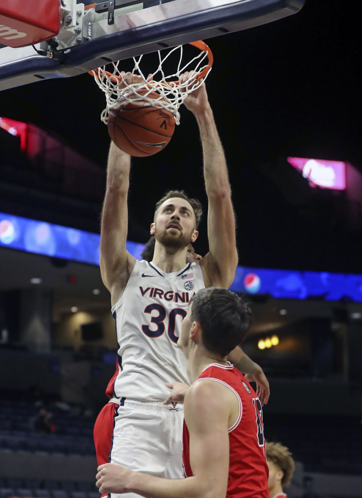 Virginia forward Jay Huff (30) dunks the ball in front of St. Francis forward Mark Flagg (42) during an NCAA college basketball game, Tuesday, Dec. 1, 2020 in Charlottesville, Va. (Andrew Shurleff/The Daily Progress via AP)