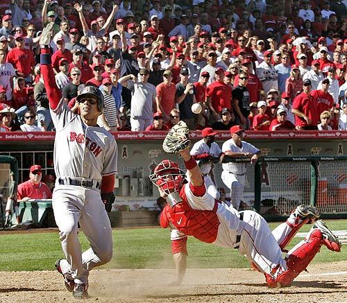 Boston's Julio Lugo celebrates after sliding home safely against the Angels. The Red Sox swept the Angels in the first round of the American League playoffs. Los Angeles was outscored, 19-4, in three games.