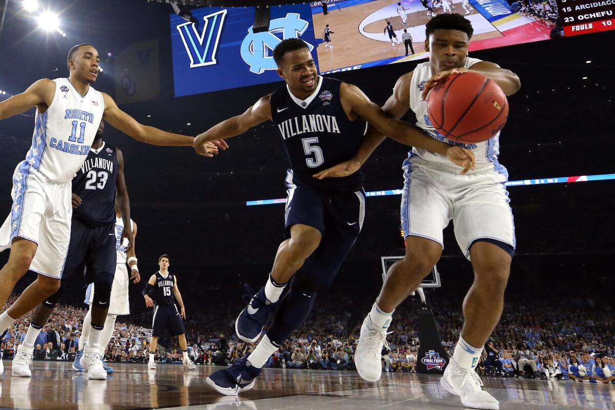 Phil Booth, center, of Villanova fights Isaiah Hicks, right, of North Carolina for the ball during the 2016 NCAA Men's Final Four National Championship game on April 4, 2016, in Houston, Texas.