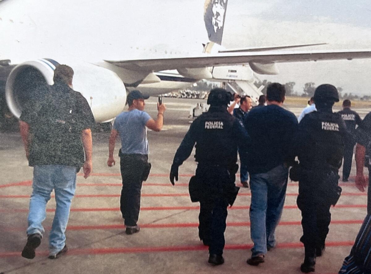 Jose Luis Saenz is escorted by Mexican federal police onto an Alaska Airlines flight.