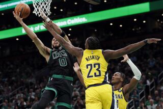 Jayson Tatum (0), de los Celtics de Boston, dispara en contra de la marca defensiva de Aaron Nesmith (23), de los Pacers de Indiana, durante la primera mitad del juego de baloncesto de la NBA, el viernes 24 de marzo de 2023, en Boston. (AP Foto/Michael Dwyer)