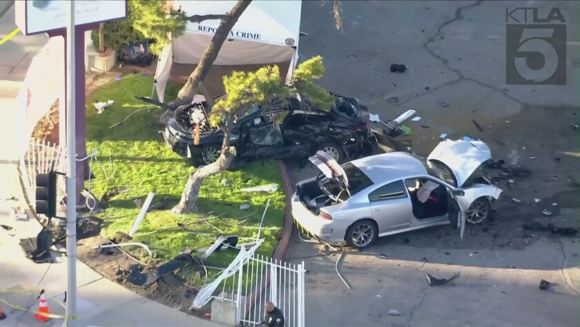 Two smashed cars are shown surrounded by debris at a crash scene.