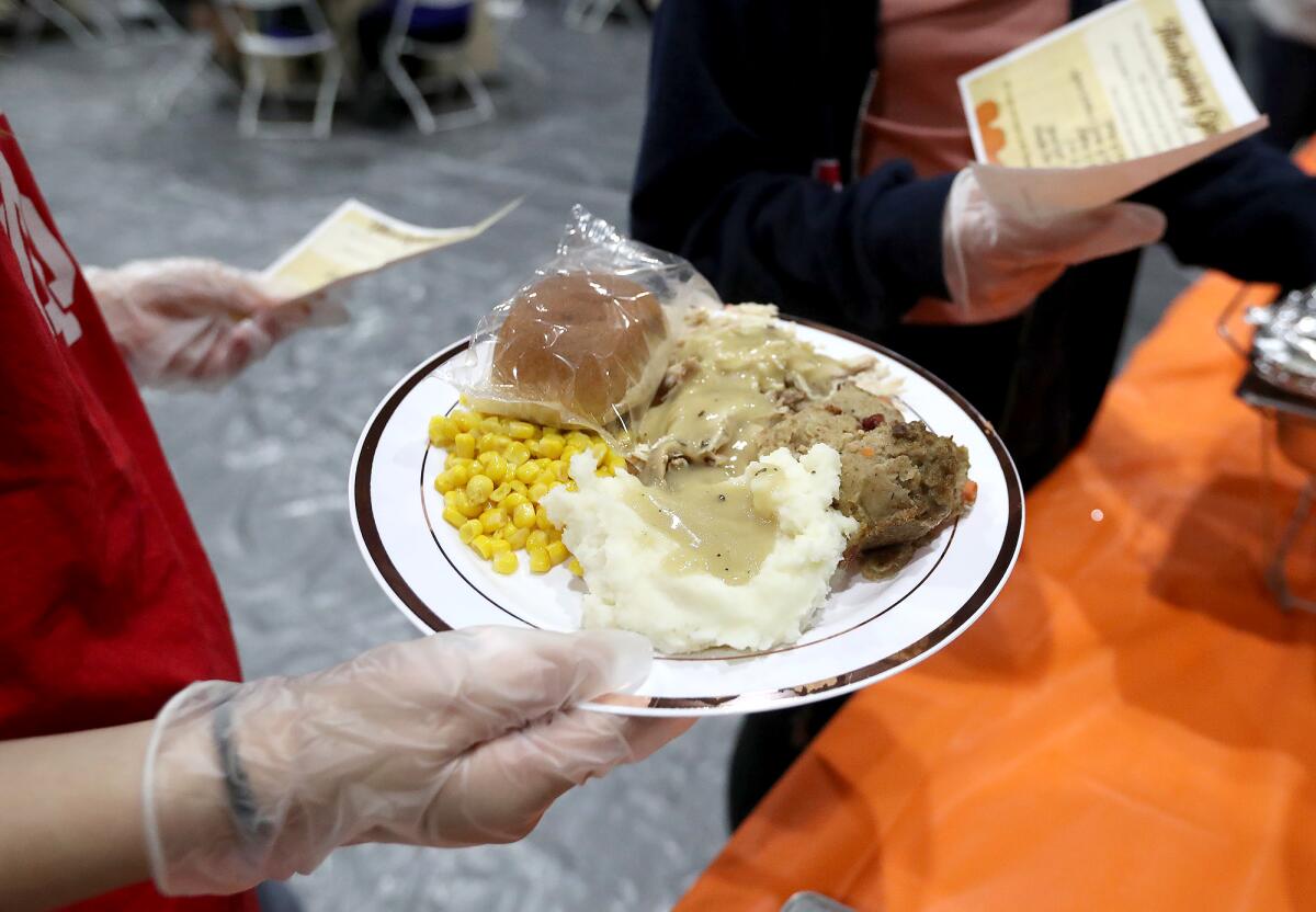 Volunteers fill plates at the Thanksgiving dinner at the Santa Ana Boys & Girls Club.