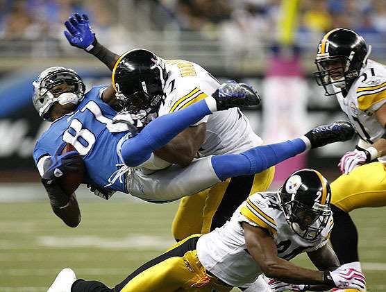 Calvin Johnson of the Detroit Lions is tackled by James Harrison of the Pittsburgh Steelers on October 11 at Ford Field in Detroit, Michigan. Johnson was injured on the play.
