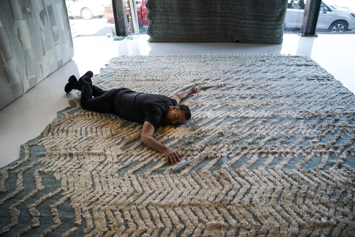 But is it love? Interior designer Adam Hunter tries out a rug — a design named Zig Zig Zag — at Mehraban in Los Angeles.