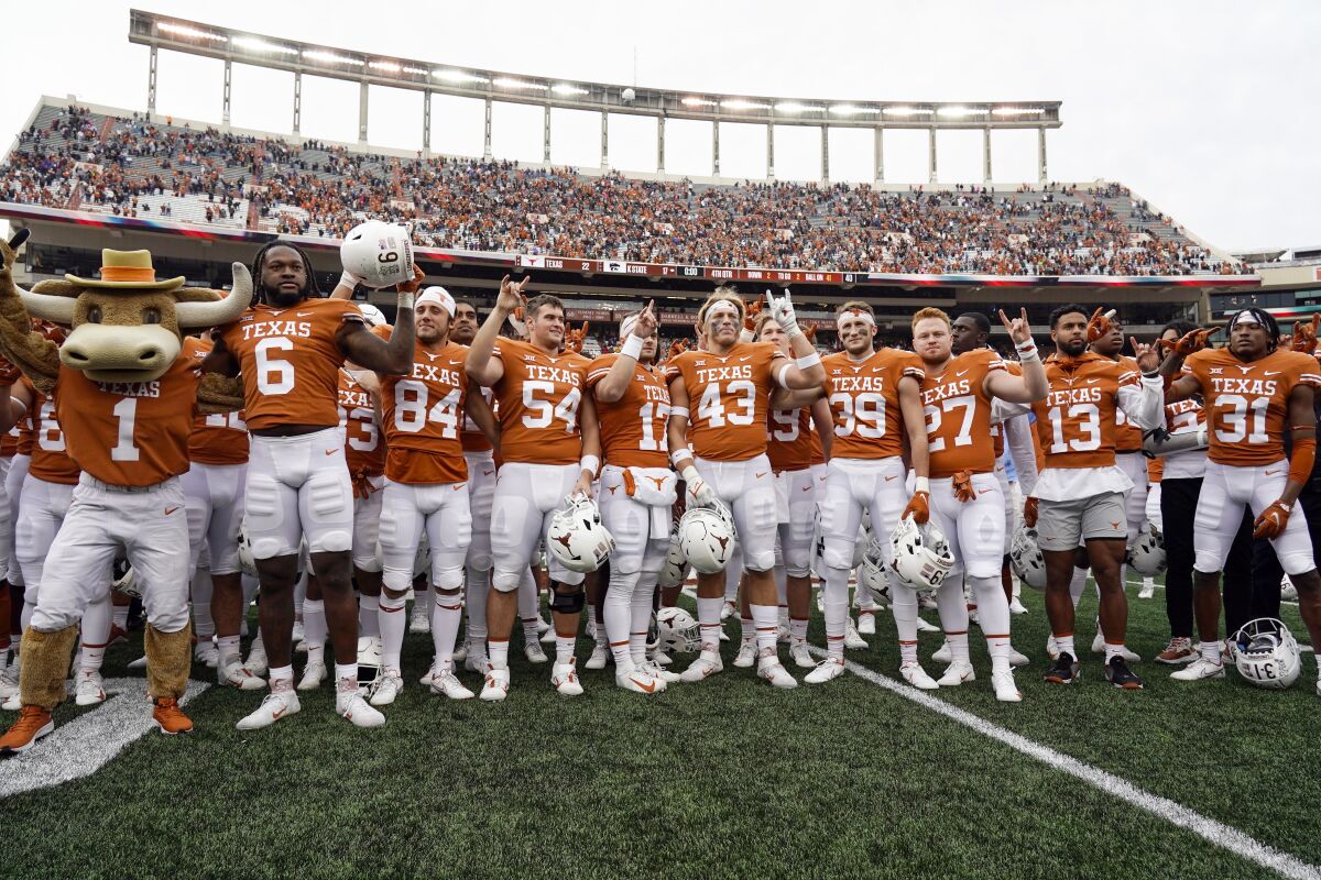 FILE - Texas players sing "The Eyes Of Texas," after defeating Kansas State 22-17 in an NCAA college football game in Austin, Texas, on Nov. 26, 2021. The new business world of college athletes getting paid for endorsements has created a rapidly expanding pop-up industry: nonprofits formed to set up athletes with deals that pay them to promote charities. Among the first was Horns With Heart, a nonprofit set up to aid offensive linemen at the University of Texas in 2021. A bill filed Wednesday, Sept. 28, 2022, would eliminate the tax deduction for individuals and for specific contributions that are then paid to athletes for name, image and likeness deals. (AP Photo/Chuck Burton, File)