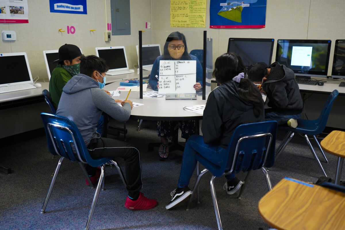 Selena Hernandez, a bilingual instructional aide at Oak Crest Middle School in Encinitas, works with her students.