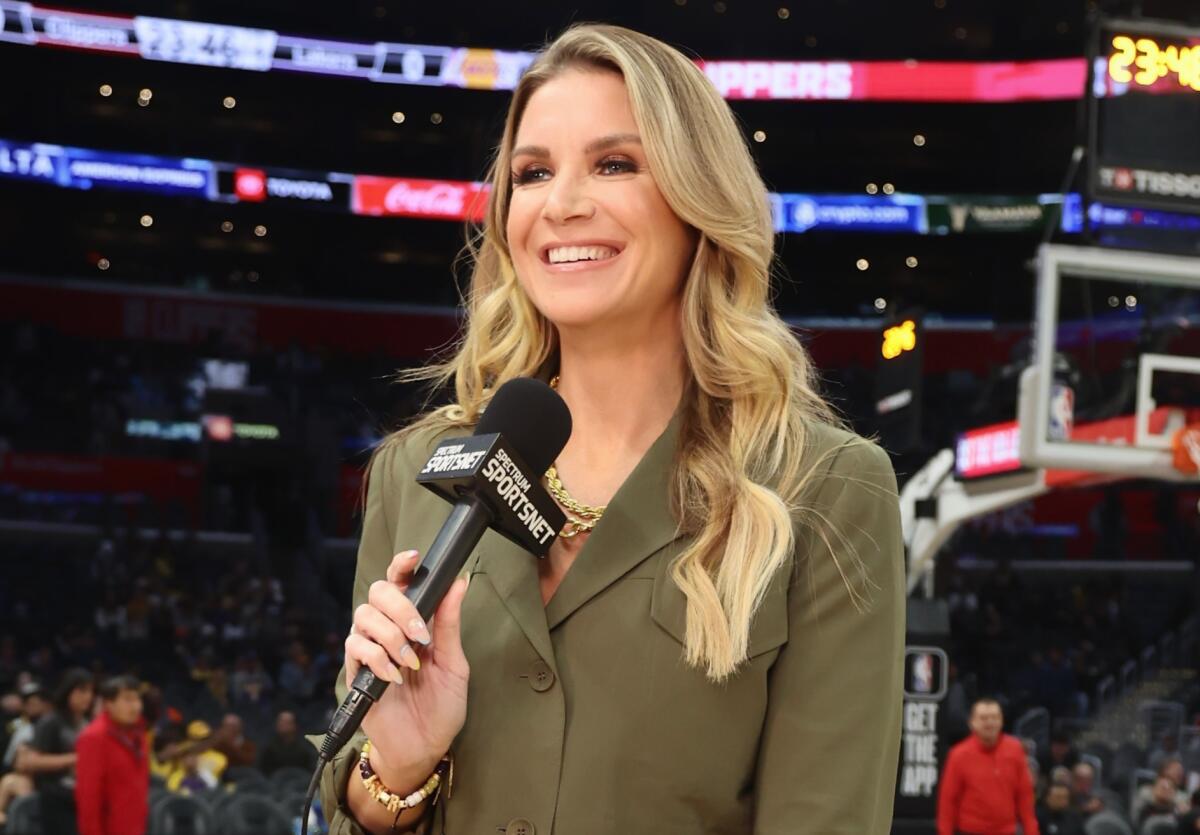 Allie Clifton holds a microphone and stands on the court as she reports on a Lakers-Clippers game at Crypto.com Arena.