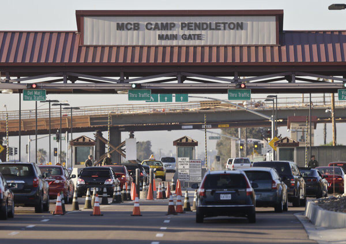 Vehicles file through the main gate of Camp Pendleton Marine Base on Wednesday. Four Marines were killed in an accident on the base.