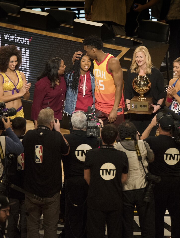 Donovan Mitchell of the Utah Jazz kisses his sister before accepting the trophy for winning Slam Dunk Contest at Staples Center.