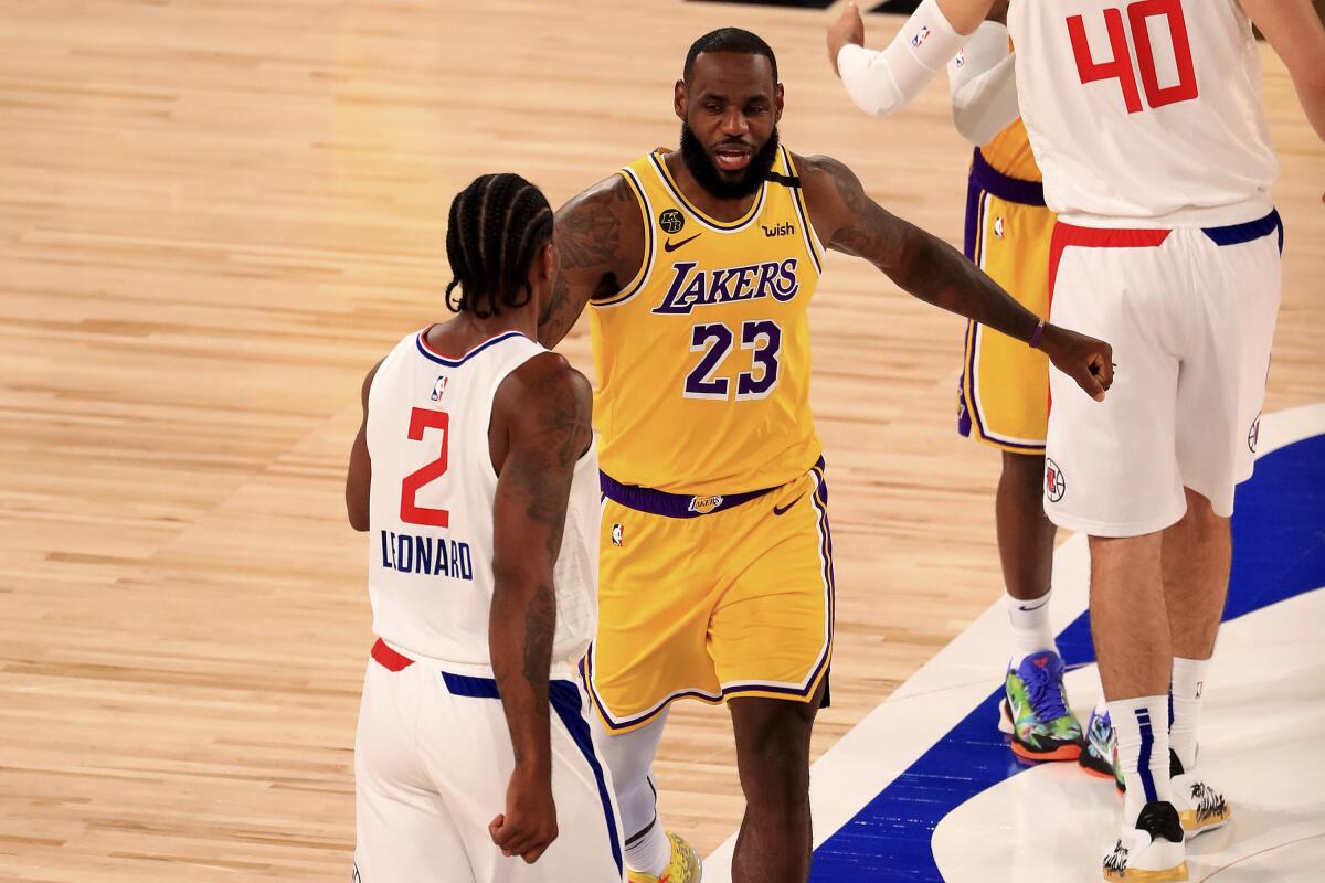 Lakers star LeBron James greets Clippers star Kawhi Leonard before their game last Thursday.