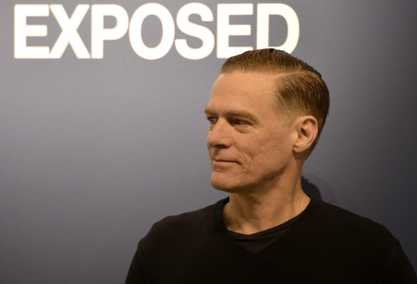 FILE - Canadian rock star Bryan Adams poses during the opening of his photo exhibition in Duesseldorf, Germany, on Feb. 1, 2013. Bryan Adams took a break Monday from his coronavirus quarantine in Milan to virtually unveil the 2022 Pirelli Calendar that he shot featuring fellow musicians including Iggy Pop, Cher and Jennifer Hudson. Adams tested positive for the virus on Thursday after arriving in Milan for events surrounding the release of the famed Pirelli calendar after a one-year hiatus due to the pandemic. (AP Photo/Martin Meissner)