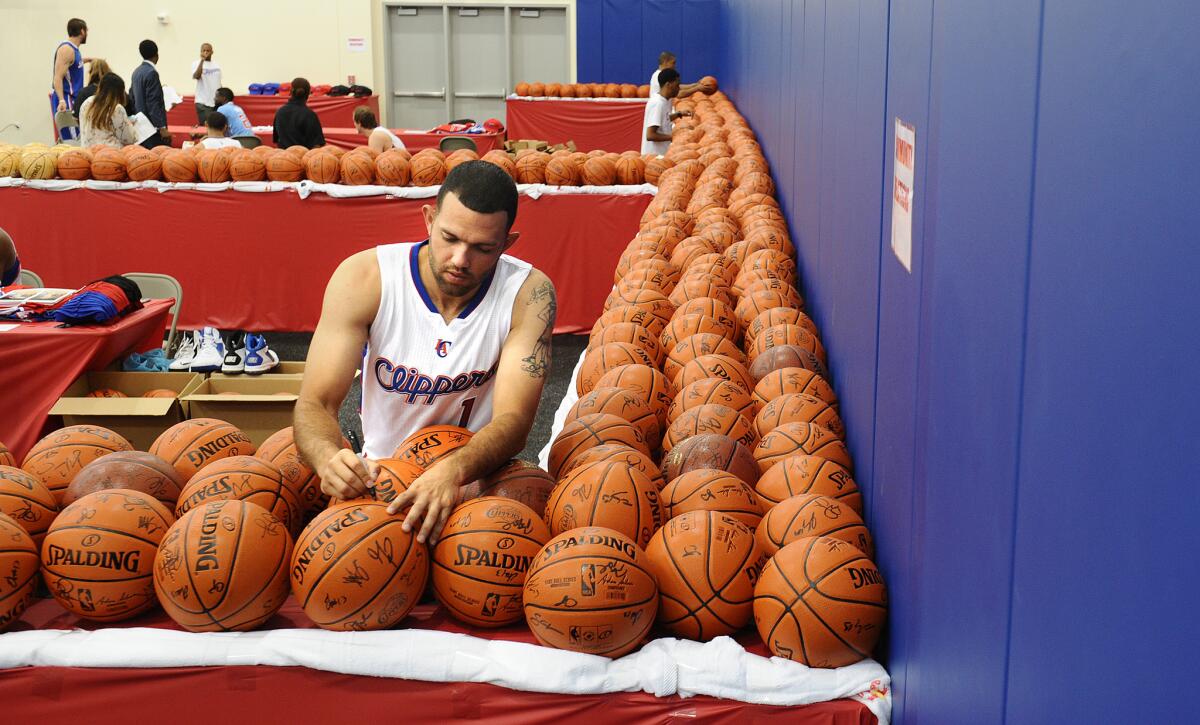 Jordan Farmar signs hundreds of basketballs during Clippers media day Monday in Playa Vista.
