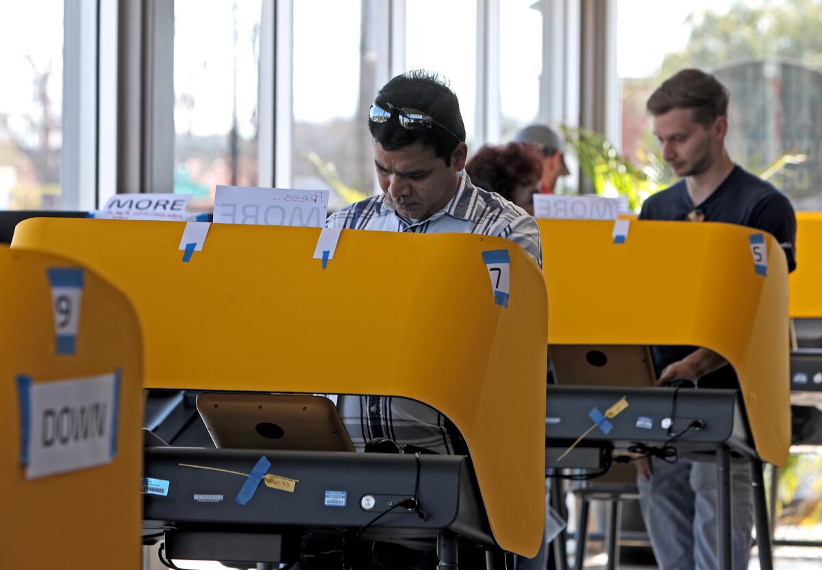 Local residents like Ravi Madugula, front, voted at IMX Auto Group, located at 811 N. Victory Blvd., Burbank on Tuesday.