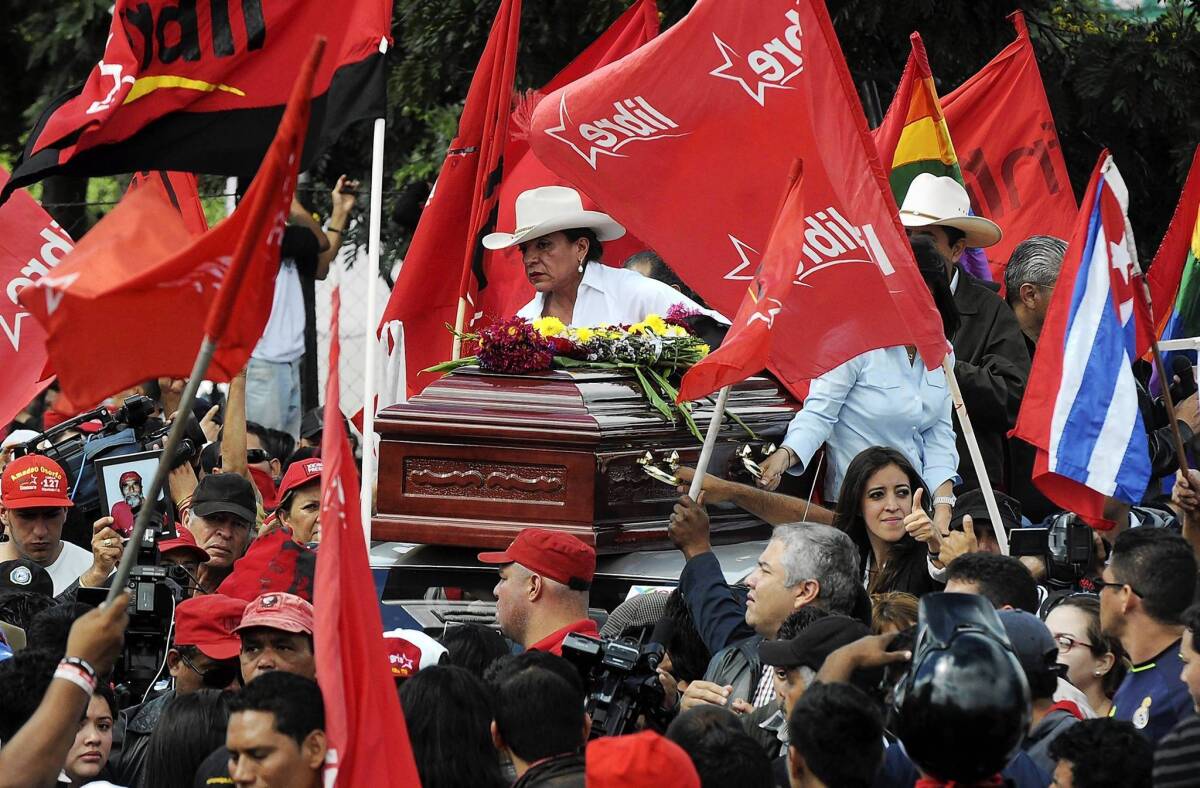 In Tegucigalpa, Honduras, presidential runner-up Xiomara Castro rides on the roof of a car carrying the coffin of a supporter killed a day earlier during a protest.