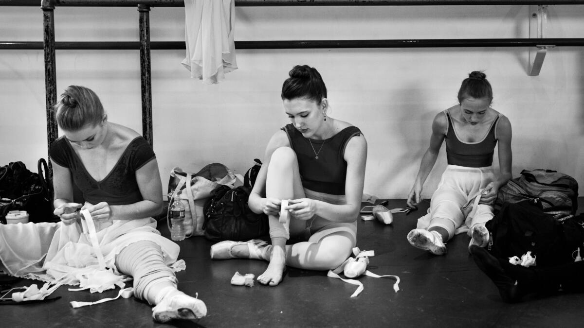 Los Angeles Ballet dancers Bianca Bulle, from left, Allyssa Bross and Ashley Millar tape their feet and prepare their pointe shoes for rehearsal at LAB's studios in West L.A. in April.