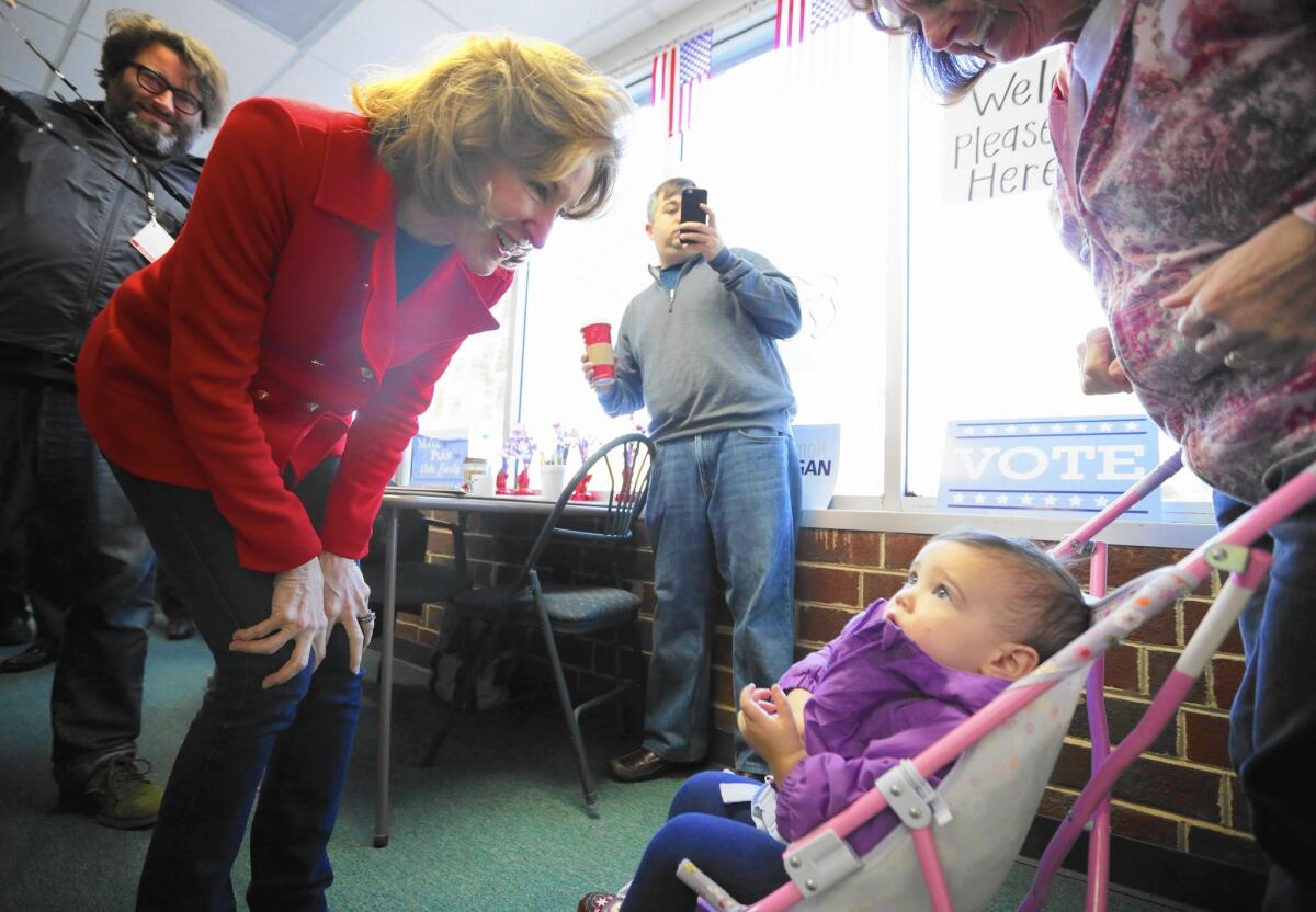 Sen. Kay Hagan (D-N.C.) greets a family on the campaign trail. Her bitter reelection race with Republican Thom Tillis has cost $107 million so far.