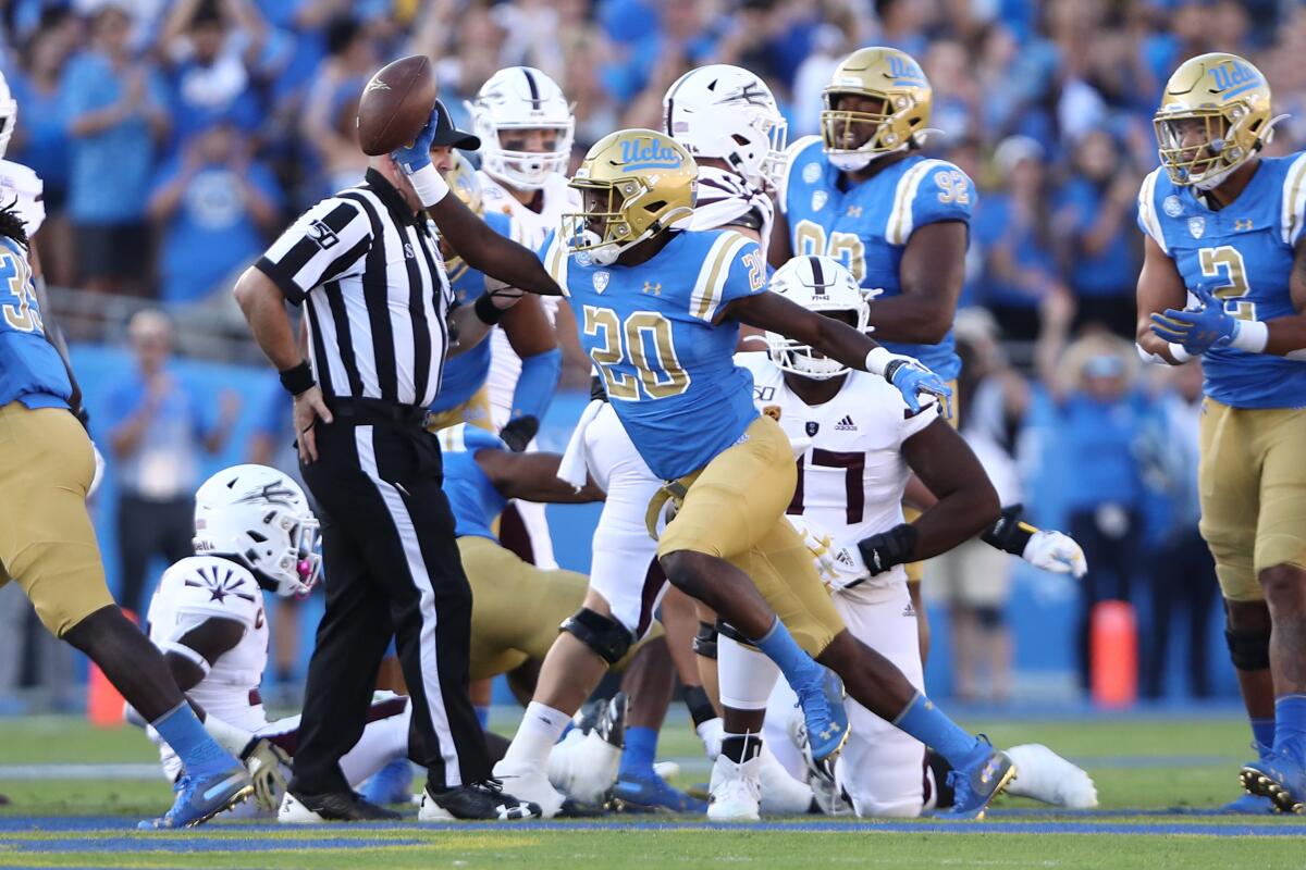 UCLA defensive back Elisha Guidry holds up the ball after recovering a fumble during the first half of a game against Arizona State.