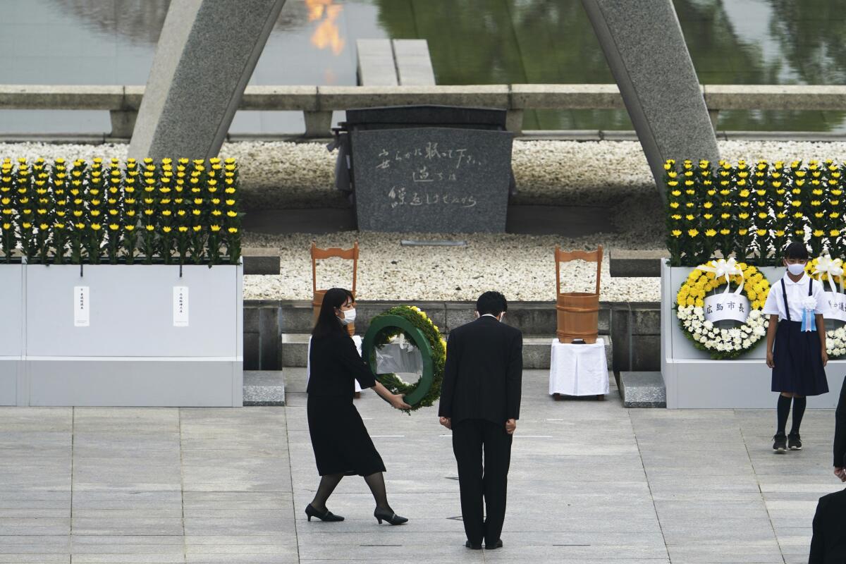 Japanese Prime Minister Shinzo Abe offers flowers to the Hiroshima Memorial cenotaph during Thursday's ceremony.