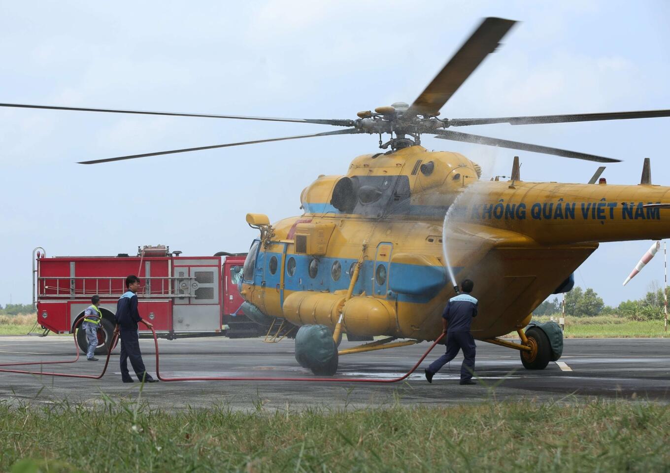 Workers spray a Vietnam Air Force Russian-made MI-17 helicopter at an airport in Ca Mau city after a search operation for the missing Malaysia Airlines flight MH370 plane over the U Minh jungle in southern province of Ca Mau.